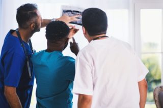 שלושה רופאים בודקים יחד צילום רנטגן